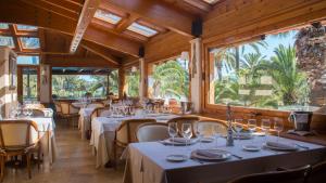 un restaurante con mesas, sillas y ventanas grandes en Hotel restaurant Ceferino, en Vilanova i la Geltrú