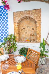 a table with wine glasses and a stone fireplace at Casa Marinero - Patio Andaluz in Barbate