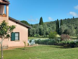 una casa con un patio con sillas y un lago en Podere S.Giulia - casale S.Giulia, en Riotorto