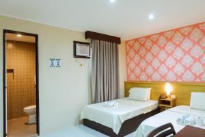 um quarto de hotel com duas camas e um WC em Hotel Juliano em Manila