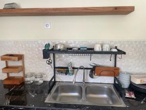 a kitchen with a sink and a shelf above it at Sandz House in Jembrana +56 photos