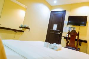 um quarto com uma cama, um espelho e uma porta em Hotel Juliano em Manila