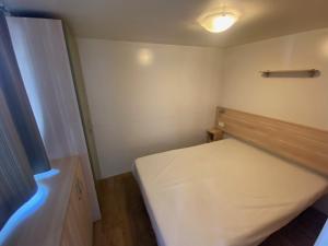 a small bedroom with a bed and a light at Mobilhomes SKALLA CZ in Martinsicuro