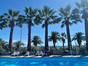 a swimming pool with palm trees in the background at Mobilhomes SKALLA CZ in Martinsicuro