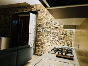 uma cozinha com um fogão e uma parede de pedra em Bombrelais em Apice