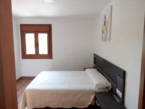 - une chambre avec un grand lit et une fenêtre dans l'établissement Cuadra, à Villanueva de Arosa