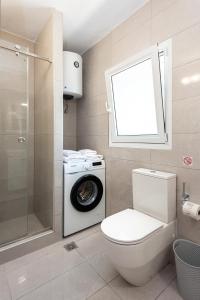 een badkamer met een toilet en een wasmachine bij Corfu Villa Olympia in Perama