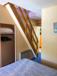 a bedroom with a bunk bed and a staircase at Logis Hotel Restaurant Mas de la Prairie in Le Vigan