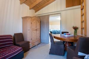 een woonkamer met een houten tafel en stoelen bij Corfu Villa Olympia in Perama