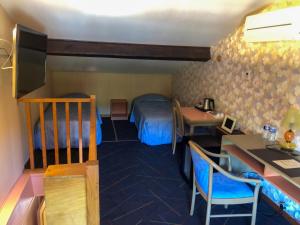 een hotelkamer met een bed, een bureau en een tafel bij Logis Hotel Restaurant Mas de la Prairie in Le Vigan