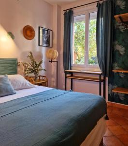 Schlafzimmer mit einem Bett, einem Fenster und einem Schreibtisch in der Unterkunft Les Lauriers in Saint-Tropez
