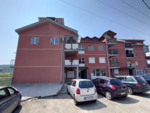 un grupo de coches estacionados frente a un edificio en Apartman Hana en Gornja Toplica