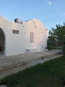 un edificio blanco con un arco junto a un patio en Maison de vacance pour les amateurs de la nature, en Kelibia
