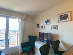 une chambre avec deux chaises, une télévision et une fenêtre dans l'établissement Studio Aix-les-Bains, 1 pièce, 2 personnes - FR-1-617-52, à Aix-les-Bains