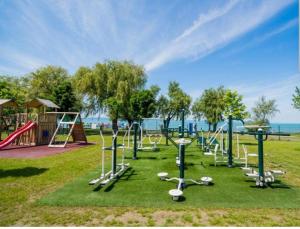 a park with a playground with a slide and swings at Silver Side Apartments in Siófok