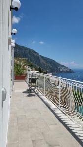 balkon ze stołem i widokiem na ocean w obiekcie Cottage L'Americano w mieście Positano