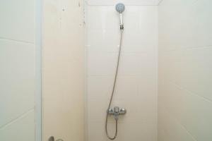 a shower with a shower head in a bathroom at Mroom Residence near UMN Gading Serpong RedPartner in Tjitjajur-hilir +21 photos