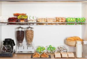a kitchen shelf with food and other food items at Fyl Hotel Dunkerque Saint Pol sur Mer in Cité Égalité