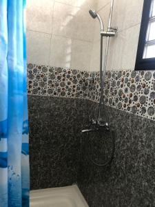 a shower in a bathroom with a sink and a toilet at Hôtel Tropicana Majunga in Mahajanga