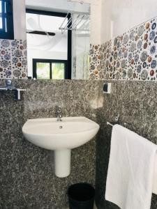 a bathroom with a sink and a mirror at Hôtel Tropicana Majunga in Mahajanga