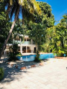 a resort with a swimming pool and palm trees at Hôtel Tropicana Majunga in Mahajanga
