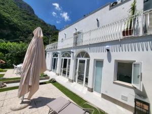 a patio with an umbrella and a building at Cottage L'Americano in Positano