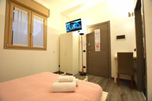 シルミオーネにあるHarmony Sirmione - Affitti Brevi Italiaのベッド1台、テレビが備わる客室です。