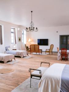 a large room with two beds and a flat screen tv at Demeure de kergoguen in Plougonver