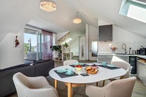 Loft Schwenck في كريسبرون ام بوندنس: مطبخ وغرفة معيشة مع طاولة وكراسي