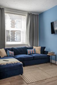 niebieski salon z niebieską kanapą i oknem w obiekcie Stay at the Marine House - TV in every bedroom! w mieście Morriston
