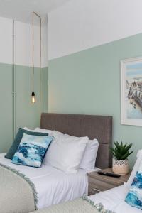 sypialnia z 2 łóżkami z białą pościelą i rośliną w obiekcie Stay at the Marine House - TV in every bedroom! w mieście Morriston