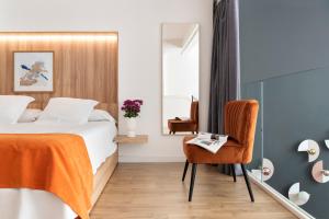um quarto de hotel com uma cama e uma cadeira em Murillo Gardens Sevilla by Magno Apartments em Sevilha