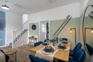 Un comedor con una mesa y sillas azules. en Parking - 2 Baths - Garden - Dining Area, en Swansea