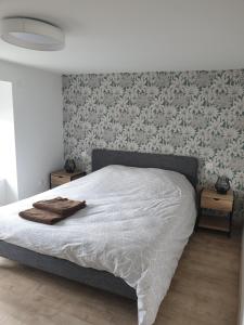 a bedroom with a bed with a white comforter at La petite Longère de Vin'Ay in Vinay +4 photos