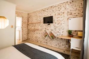 a bedroom with a white brick wall at 54 Brecher in Pretoria