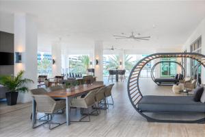 sala de estar con mesa, sillas y sofá en AC Hotel by Marriott Fort Lauderdale Airport, en Dania Beach