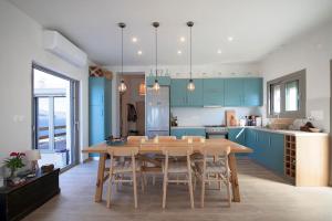 a kitchen with a wooden table and blue cabinets at Villa Kalydna in Kalymnos