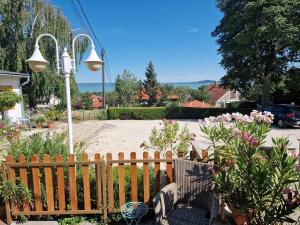 a garden with a wooden fence and flowers at Bacchus Apartman - Borbarlang, Badacsony in Badacsonytomaj