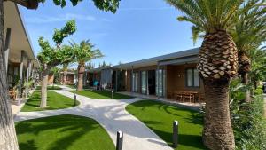 a palm tree in front of a building at Playa Montroig Camping Resort in Montroig