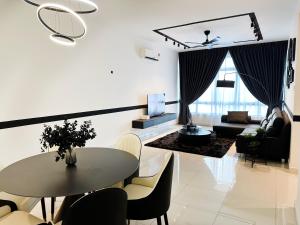 ジョホールバルにあるBotanika, Luxury Homestay by Antlerzoneのテーブルと椅子のあるリビングルーム