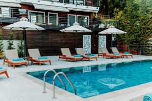 My Suite Boutique Hotel في بارغا: مسبح مع كراسي الصالة والمظلات