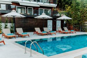 una piscina con tumbonas y sombrillas en My Suite Boutique Hotel, en Parga