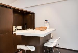 Una cocina con una encimera con taburetes blancos. en Appartement Place des lices avec Parking, en Saint-Tropez