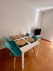 een witte tafel met vier stoelen en een laptop bij Apartamento Paraíso del Sol in Torrox Costa