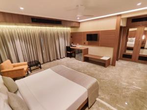 ムンバイにあるHOTEL ARCHANA RESIDENCYのベッドとデスクが備わるホテルルームです。