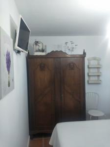 - une chambre avec une télévision et une armoire en bois dans l'établissement Las Casucas de Gema, à Isla
