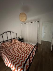 ein Schlafzimmer mit einem Bett mit einer orangen und weißen Bettdecke in der Unterkunft parc lazaro in Ajaccio
