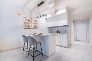 cocina con encimera y 2 taburetes en Estudio Elena - Centro, en Torremolinos
