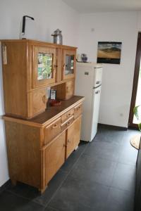 的住宿－Schönes Haus in der Wetterau，厨房配有木制橱柜和冰箱。