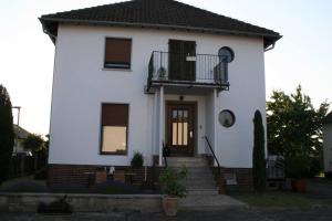 a white house with a porch and a balcony at Schönes Haus in der Wetterau in Utphe